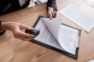 185432630 cropped view of lawyer holding stamper and pen near contract on clipboard
